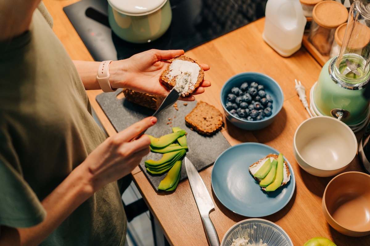 a-cropped-woman-spreads-butter-or-cheese-on-sandwi-2025-03-05-15-03-22-utc
